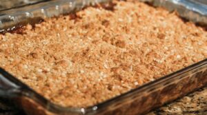 Ultra close-up macro of bubbling warm cinnamon apple crisp with golden brown oat streusel crust fresh from the oven